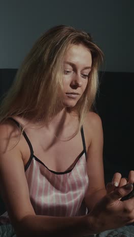 woman using a phone in pajamas at night