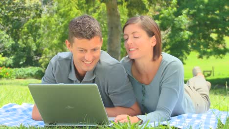 una joven pareja usando su computadora portátil