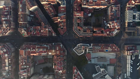 Top-down-shot-of-streets-and-road-intersections-among-town-blocks-in-urban-borough.-Barcelona,-Spain