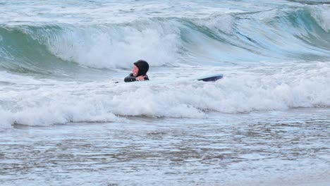 young boy surfing and falling in waves