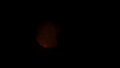 eclipse solar parcial cubierto por nubes, reemergiendo, y luego cubierto de nuevo