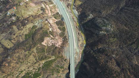 Highway-passes-through-the-valley-near-the-river-between-the-mountains-and-the-houses-in-the-north-of-Albania