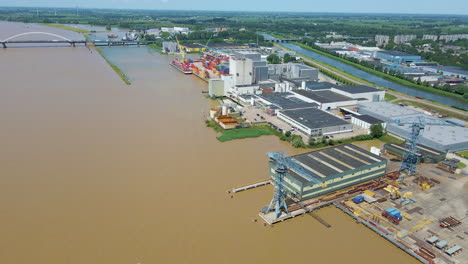 antena de edificios industriales cerca del río marrón y sucio
