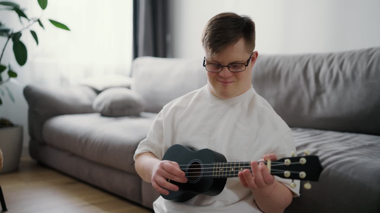 Retrato de um menino com síndrome de Down se divertindo enquanto toca ukulele em casa