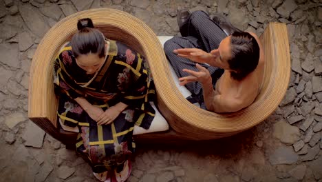 overhead shot of butoh dancers sitting on a curved chair