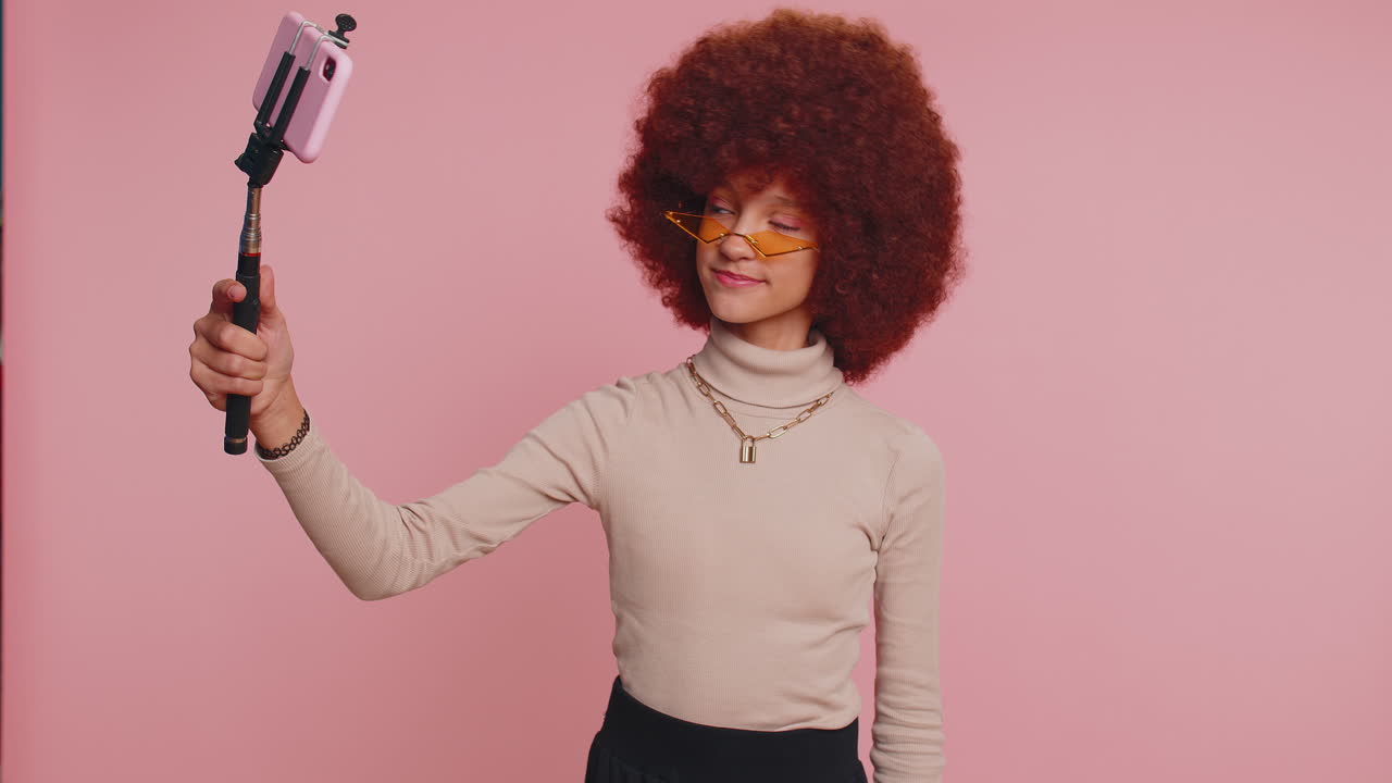 Child girl kid blogger taking selfie on smartphone communicating video call online with subscribers