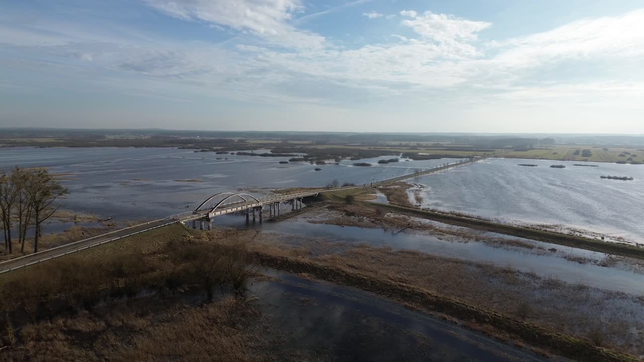 tiro aéreo largo área inundada agua río desbordamiento puente camino soleado