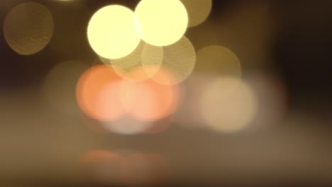 Abstract video featuring bokeh balls in warm colors, softly glowing and shifting. The soft focus creates a dreamy atmosphere, ideal for textures and effects in cinematic and artistic compositions.