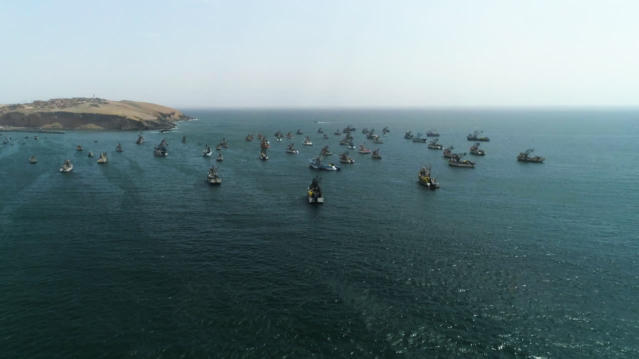 vista aérea que se acerca a los barcos de pesca anclados en la costa de huacho soleado, perú