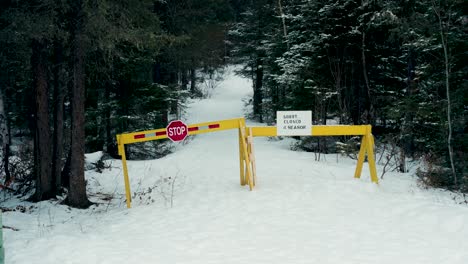 Eine-Statische-4K-Aufnahme-Eines-Winterlich-Schneebedeckten-Immergrünen-Herbstwaldes-Pisew-Falls-Federal-Park-Roadway-Wanderweg-Im-Hinterland,-Der-Wegen-Der-Saison-Durch-Gelbe-Blocker-Gesperrt-Ist.-Stoppschild,-Kein-Zutritt