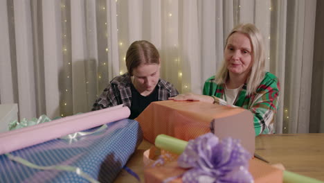 mother and daughter wrapping gifts together