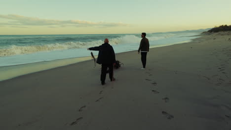 Two Men Walking Near the Stormy Ocean