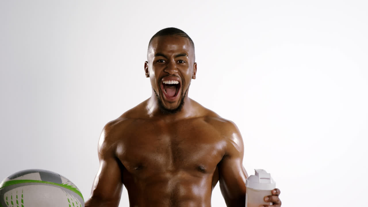 jugador de fútbol americano sosteniendo una botella de agua y una pelota de rugby