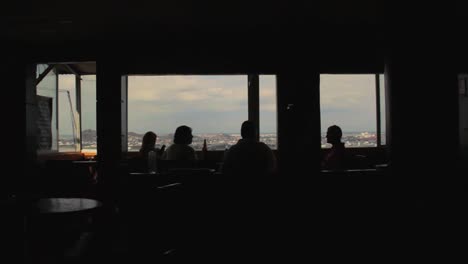 a silhouette of a group of friends having fun, drinking and eating