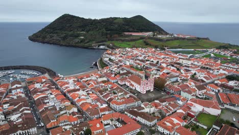 aerial tilt up shot of angra do heroismo city with bay and monte brasil