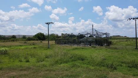 vuelo aéreo bajo a una jaula de práctica de bateo abandonada en el sur de florida