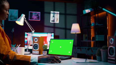African american girl working with device showing greenscreen layout