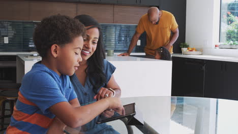 African-American-Parents-Helping-Son-Using-Digital-Tablet-To-Study-Homework-In-Kitchen