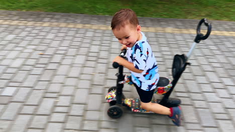 beautiful smiling baby riding his bike energetically. happy child in the park in summer.