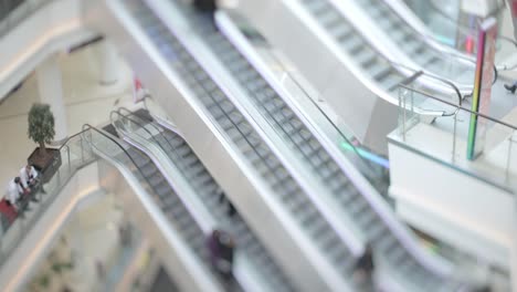 People-in-motion-in-escalators-at-the-modern-shopping-mall.-Tilt-shift-lens-shooting-with-super-shallow-depth-of-field.