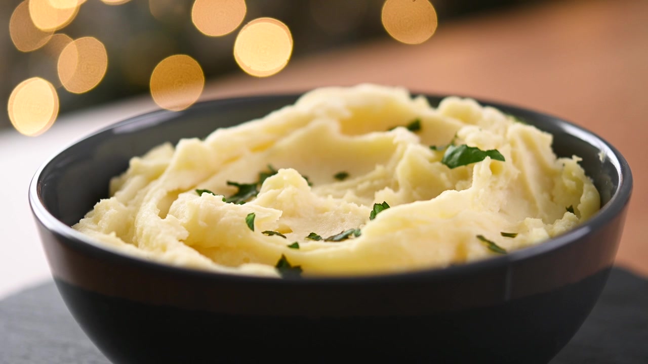 Creamy mashed potatoes rotating in a bowl