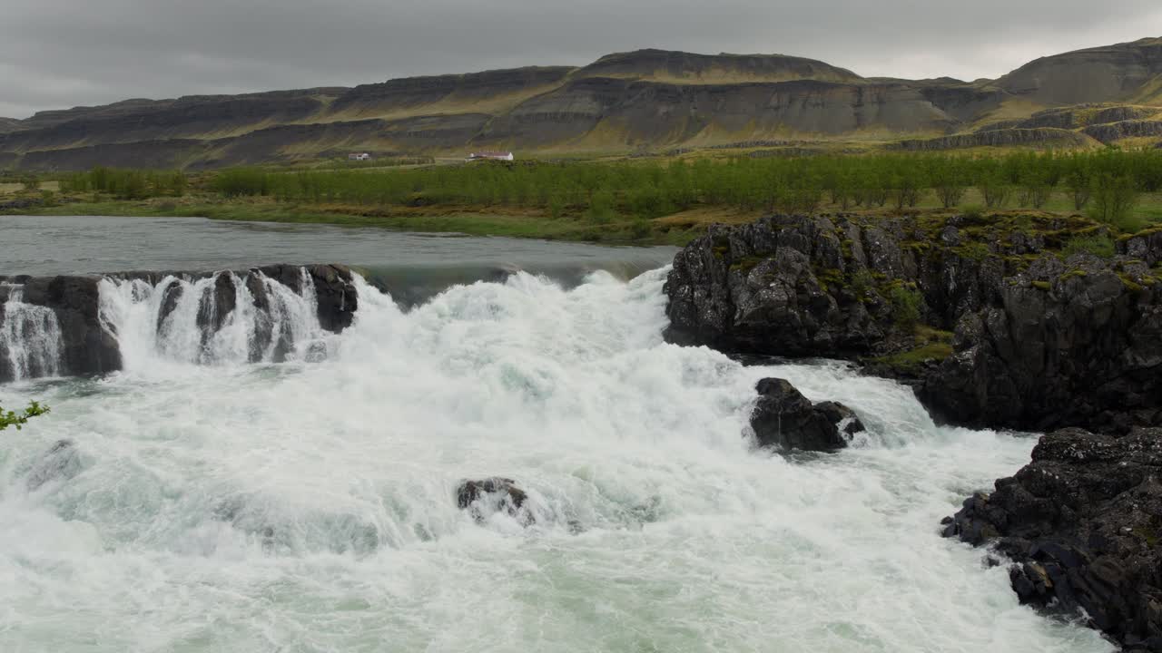una pequeña cascada en el tranquilo campo islandés en un día lluvioso