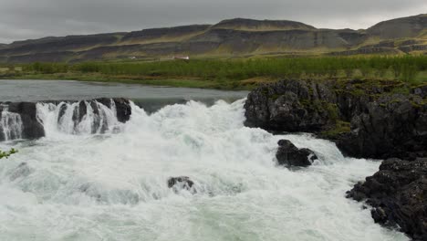 a small waterfall in the tranquil icelandic countryside on a rainy day