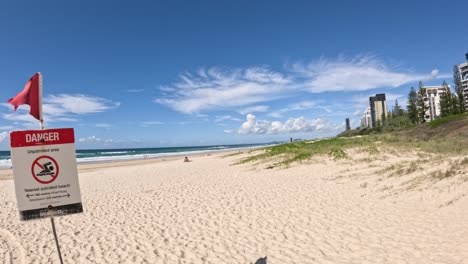 señal de advertencia en una playa soleada