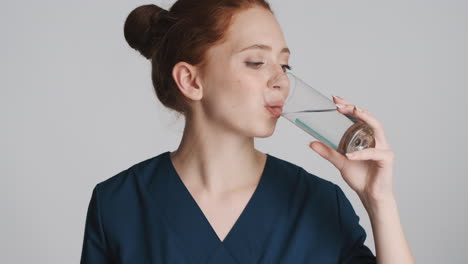 redheaded doctor in front of camera on gray background.