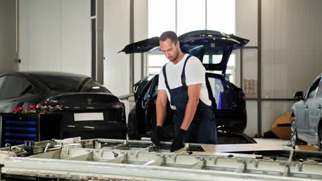 mecánico de automóviles trabajando en piezas de automóviles eléctricos en un garaje