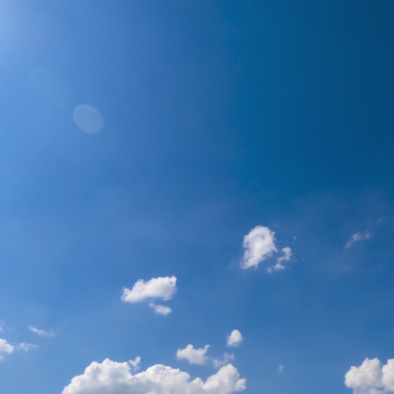 Beautiful soft light clouds transforming in the bright rays of summer sun. Low angle view timelapse