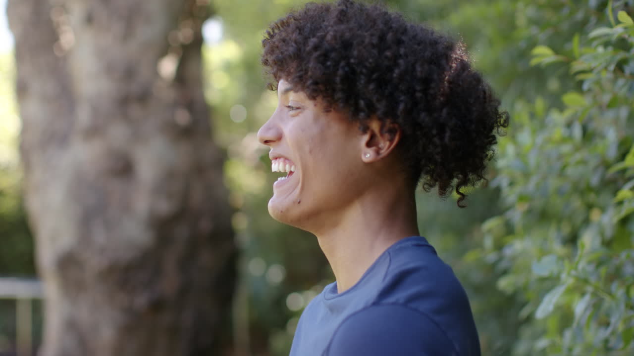 Smiling young man outdoors, enjoying nature and looking at camera, copy space
