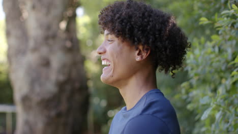 smiling young man outdoors, enjoying nature and looking at camera, copy space