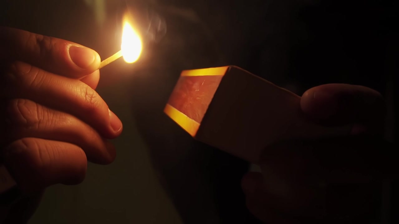 Close-up Tangan Menyalakan Korek Api dalam Gerak Lambat