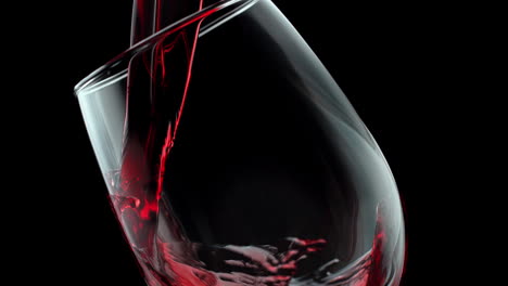 pouring red wine into a crystal glass on the black background in slow motion