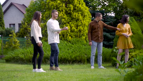 distant view of caucasian young man throwing a petanque ball in the park on a sunny day