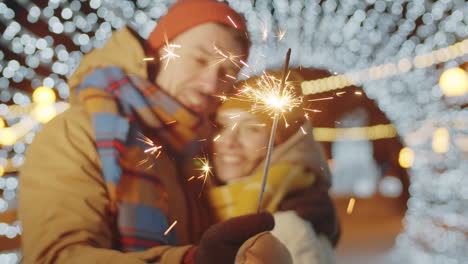 couple holding christmas sparkler and kissing