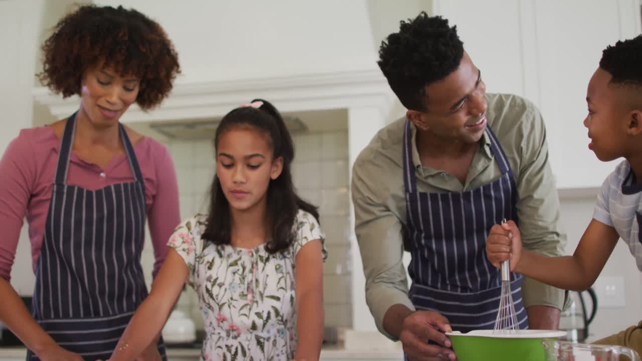 familia afroamericana horneando juntos en la cocina en casa