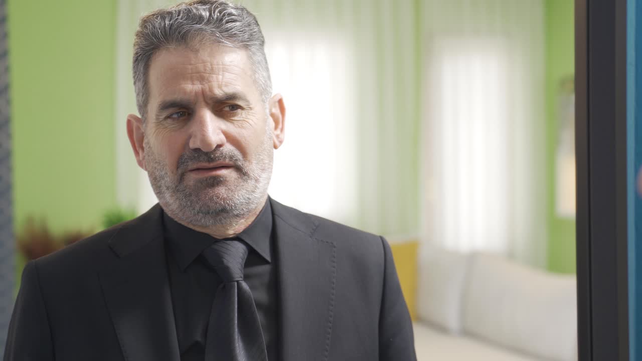 un hombre de negocios deprimido e infeliz mirándose en el espejo.