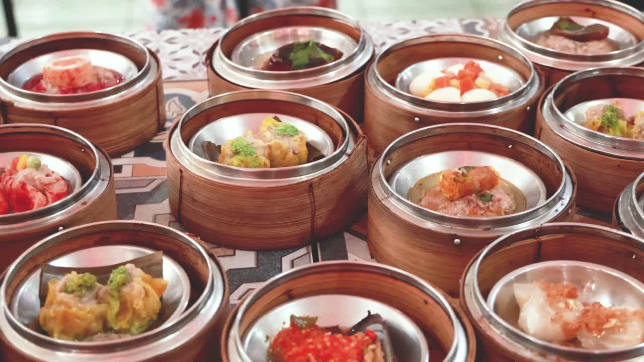 una variedad de platos de dim sum exhibidos en vaporizadores de bambú