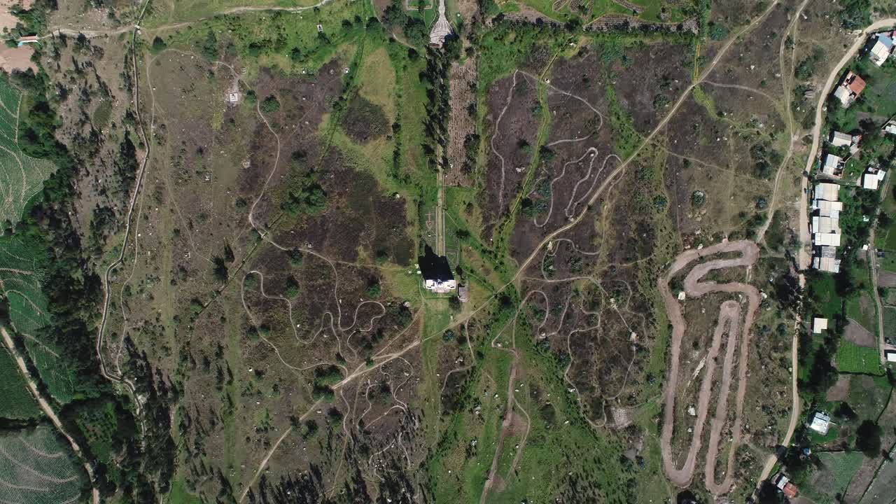 An intricate network of winding dirt trails cuts through a rugged landscape. Ideal for adventure, exploration, and topography visuals