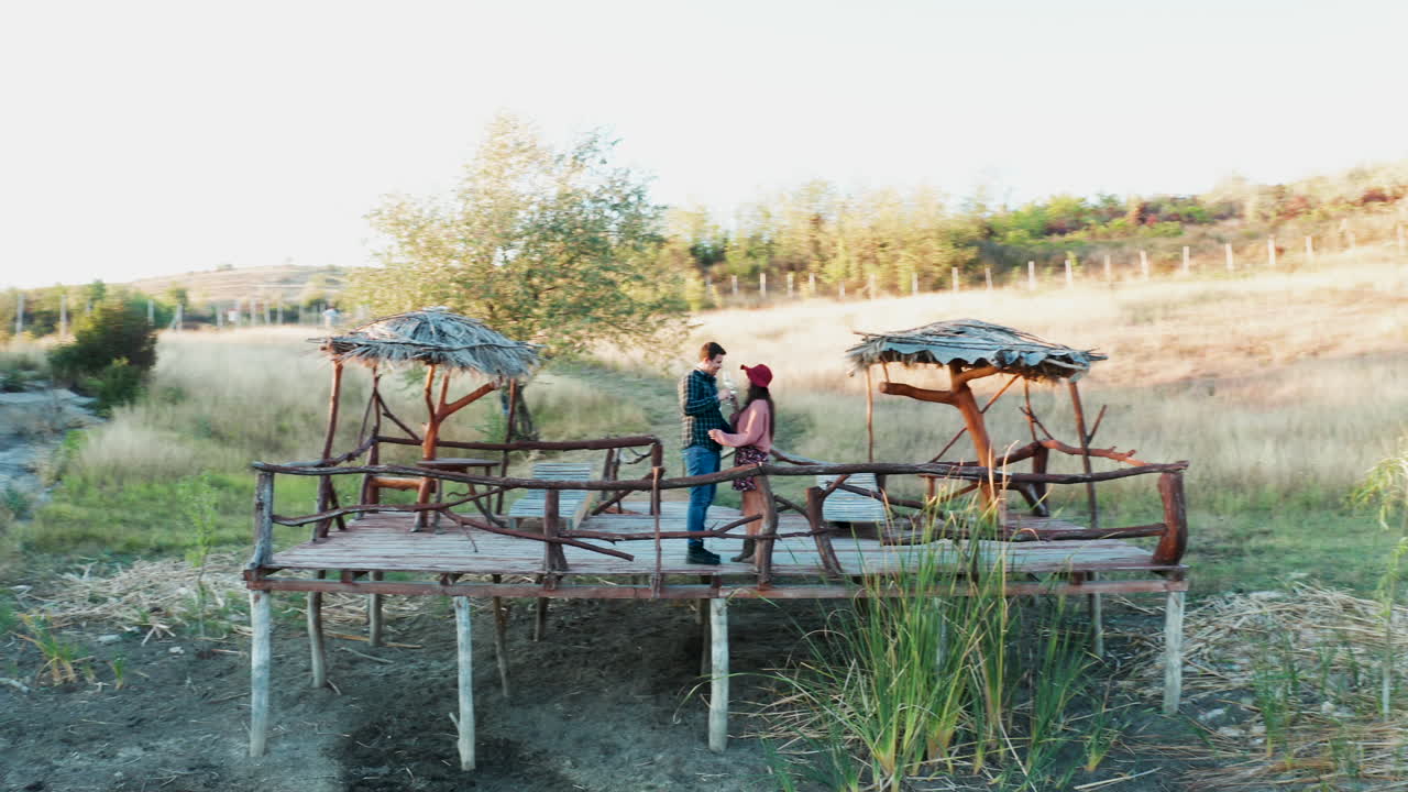 Beautiful couple clinking glasses with wine on a pontoon