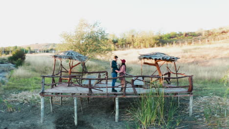 Beautiful-couple-clinking-glasses-with-wine-on-a-pontoon