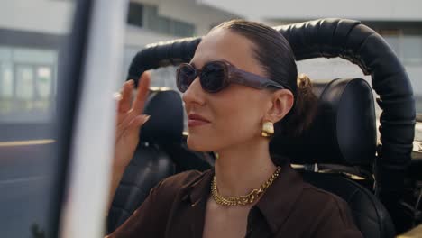 stylish woman driving an open-top car