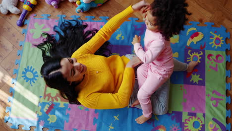 mother and child playing happily on a colorful mat