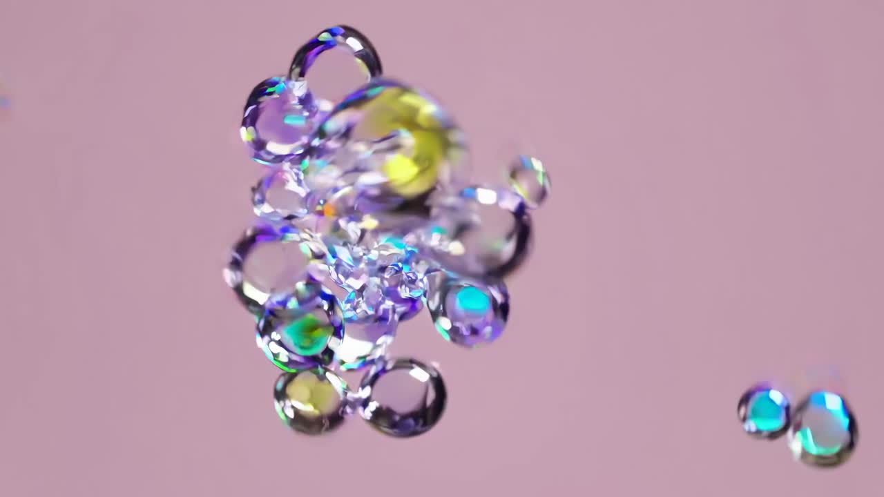 Abstract video of floating translucent bubbles with colorful reflections, captured from a close-up