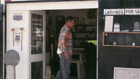 albañil de piedra de pie fuera del taller filmado en cámara roja