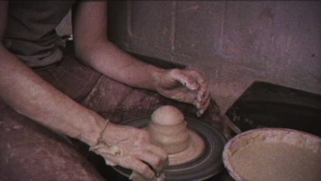 the potter makes a jug of clay. vintage effect. a man makes a vase on a potter's wheel