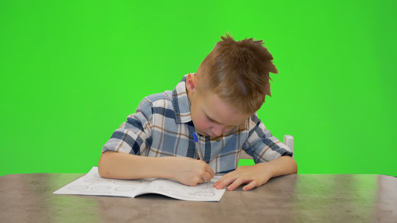 5 살짜리 소년은 노트북, 크로마 키에 글을 쓰고 있습니다.