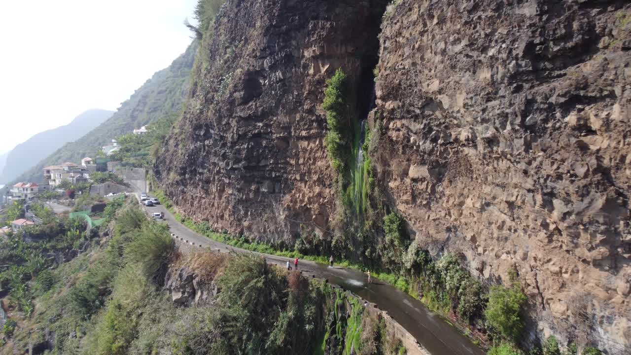 una cascada en medio de la carretera en madeira